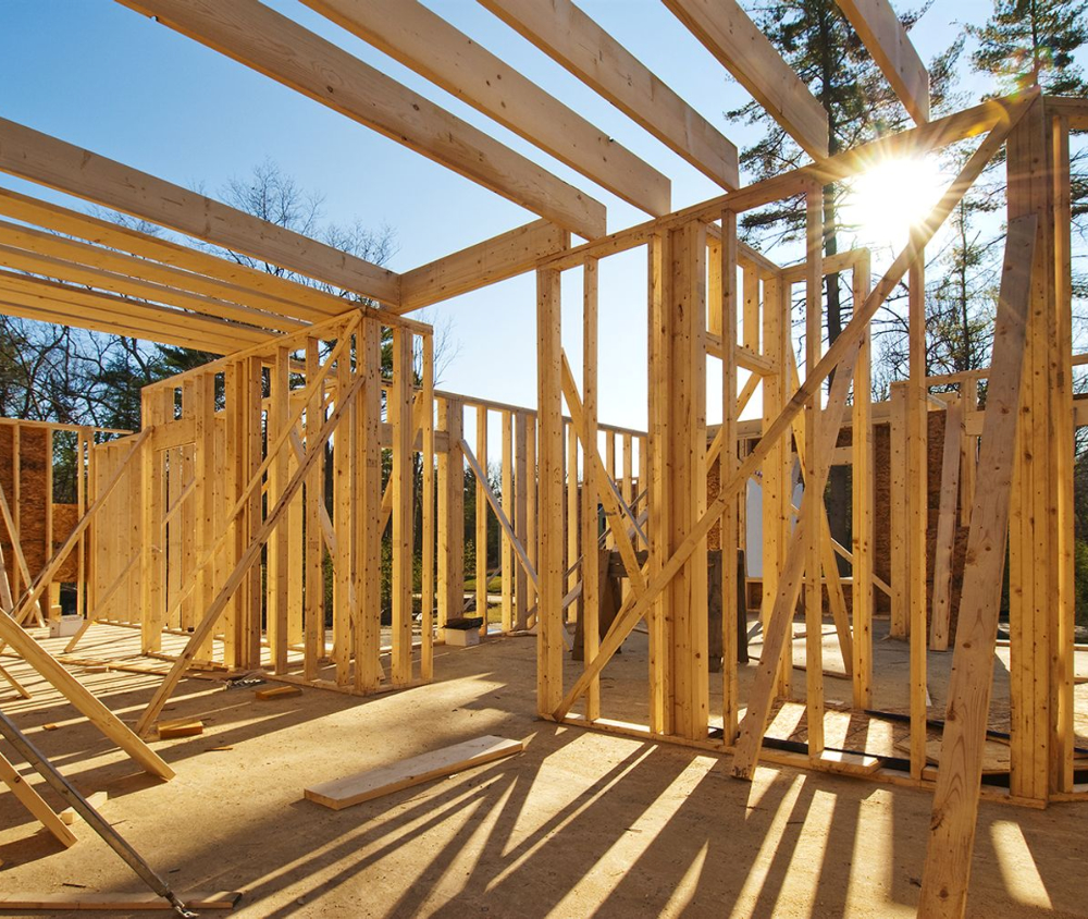 The interior structure of a detached garage framed with heavy beams and open floor space.